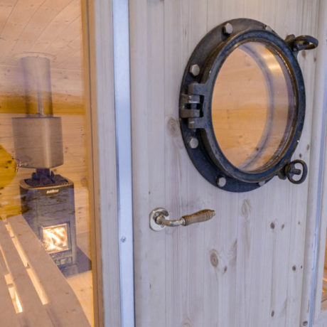 The porthole Sauna is installed on a trailer with Harvia wood oven and hot water tank.